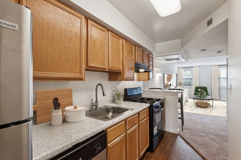 A kitchen with wooden cabinets and a stainless steel refrigerator.