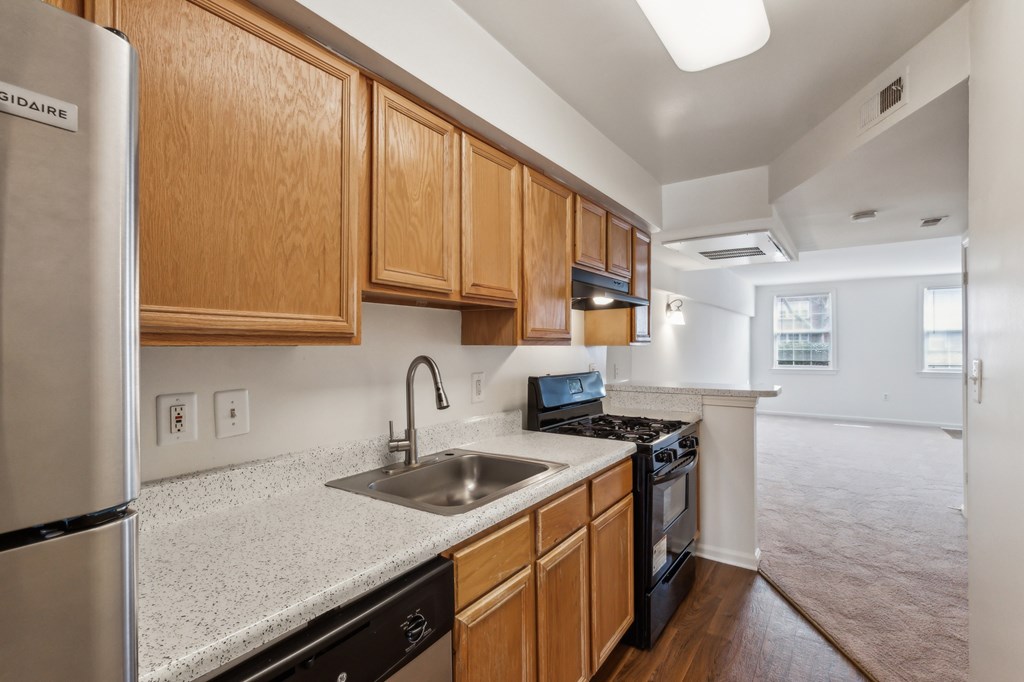 A kitchen with wooden cabinets and a stainless steel refrigerator.
