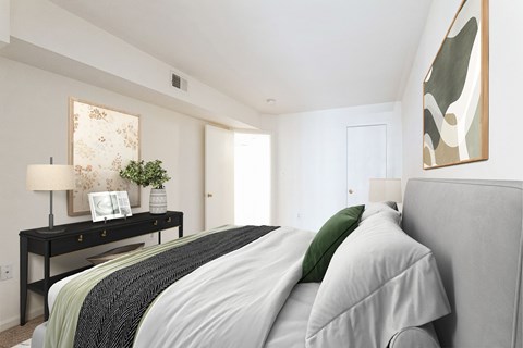 A bedroom with a bed, nightstand, and a painting on the wall.