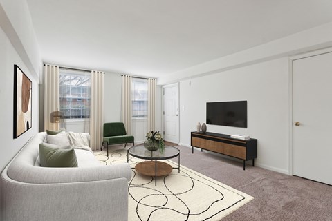A living room with a grey couch, a green chair, a coffee table, and a television.