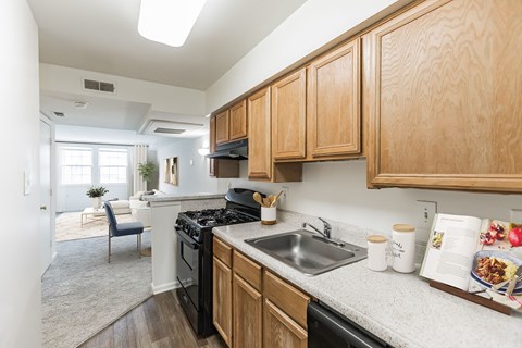 A kitchen with wooden cabinets and a black stove top oven.
