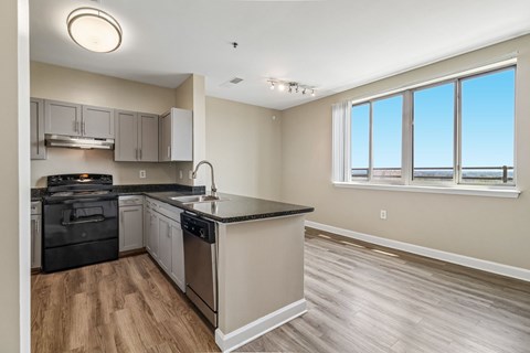 A kitchen with a black countertop and stainless steel appliances.
