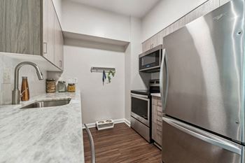 a kitchen with stainless steel appliances and marble counter tops at Lincoln Old Town, Alexandria, VA 22314
