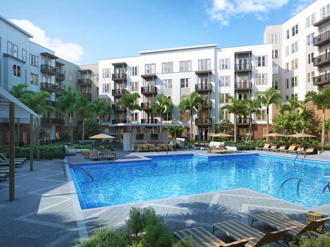 A swimming pool surrounded by lounge chairs and palm trees in front of apartment buildings.