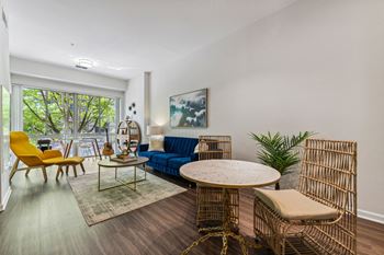 a living room with a blue couch and yellow chairs and a round table at Lincoln Old Town, Alexandria