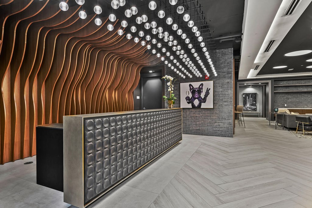 A room with a long wooden wall and a black speaker on a stand.