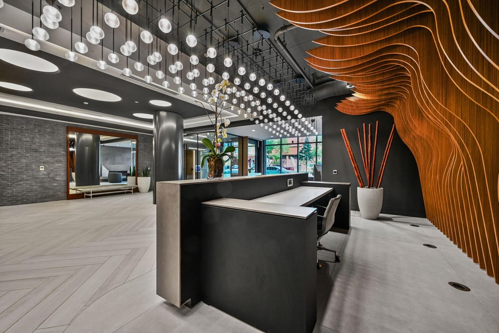 A modern office space with a reception desk and a curved wooden wall.