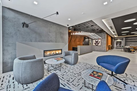 Mount Vernon Triangle, Washington, DC, High-Rise Apartments Near Georgetown University Law Center - Claret - Lobby Area With Reception Desk, Light-Colored Tiles, Pendant Lighting, Wavy Feature Wall.