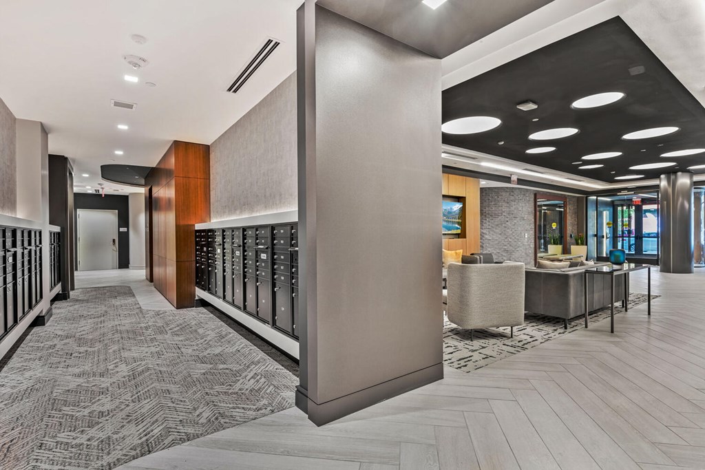 A hallway with a patterned carpet and a mix of wood and tile flooring.
