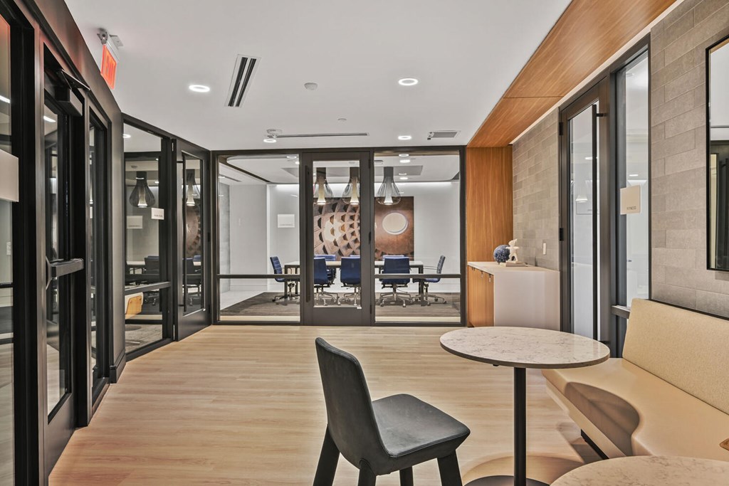 A modern office space with a wooden floor and glass walls.