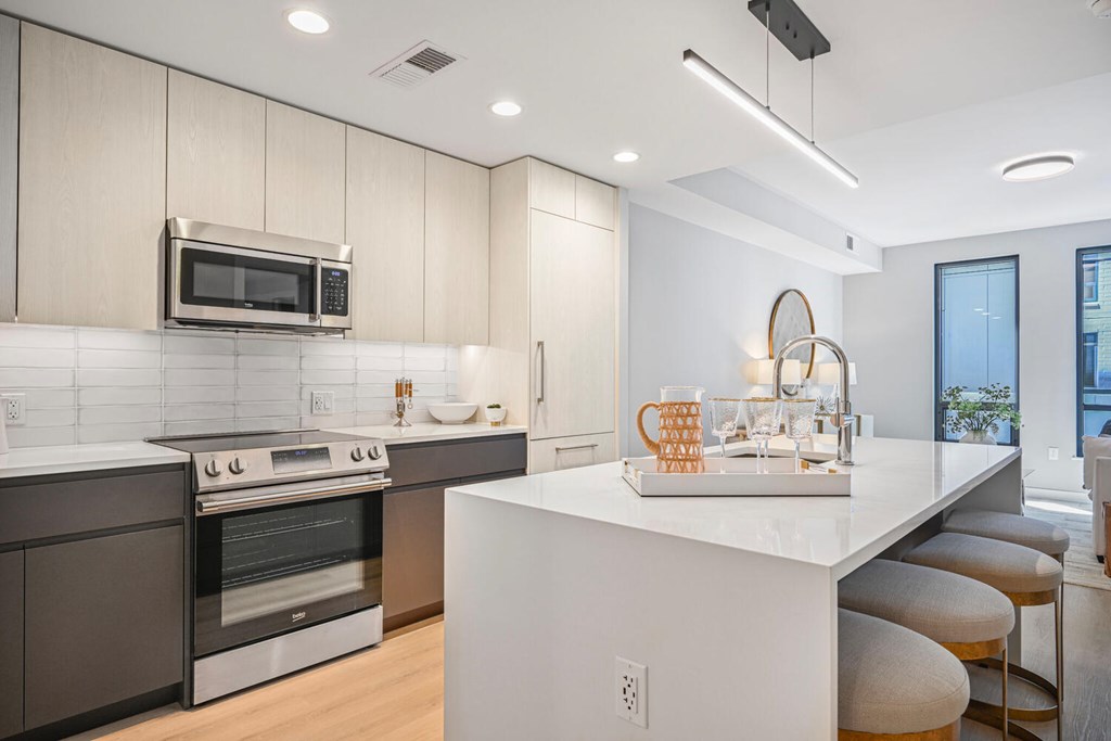 A modern kitchen with a white island and stainless steel appliances.