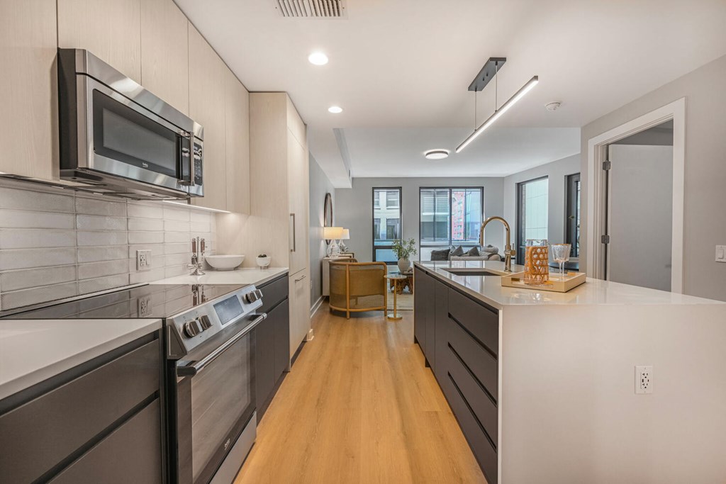 A modern kitchen with dark wood cabinets and stainless steel appliances.