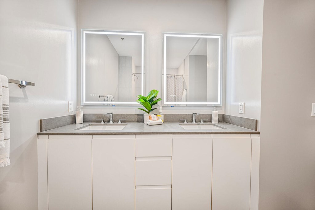 A bathroom with two sinks and a mirror.