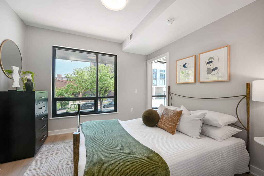 A bedroom with a large bed and a dresser.