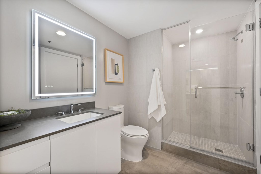 A bathroom with a toilet, sink, and shower.