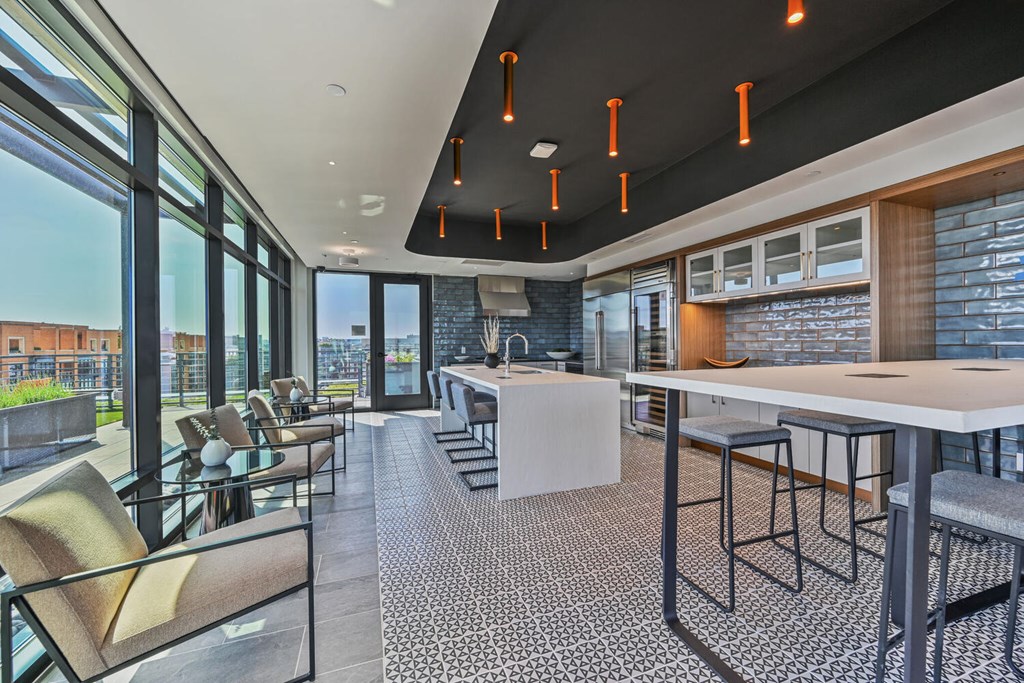 A modern kitchen and dining area with a bar and chairs.