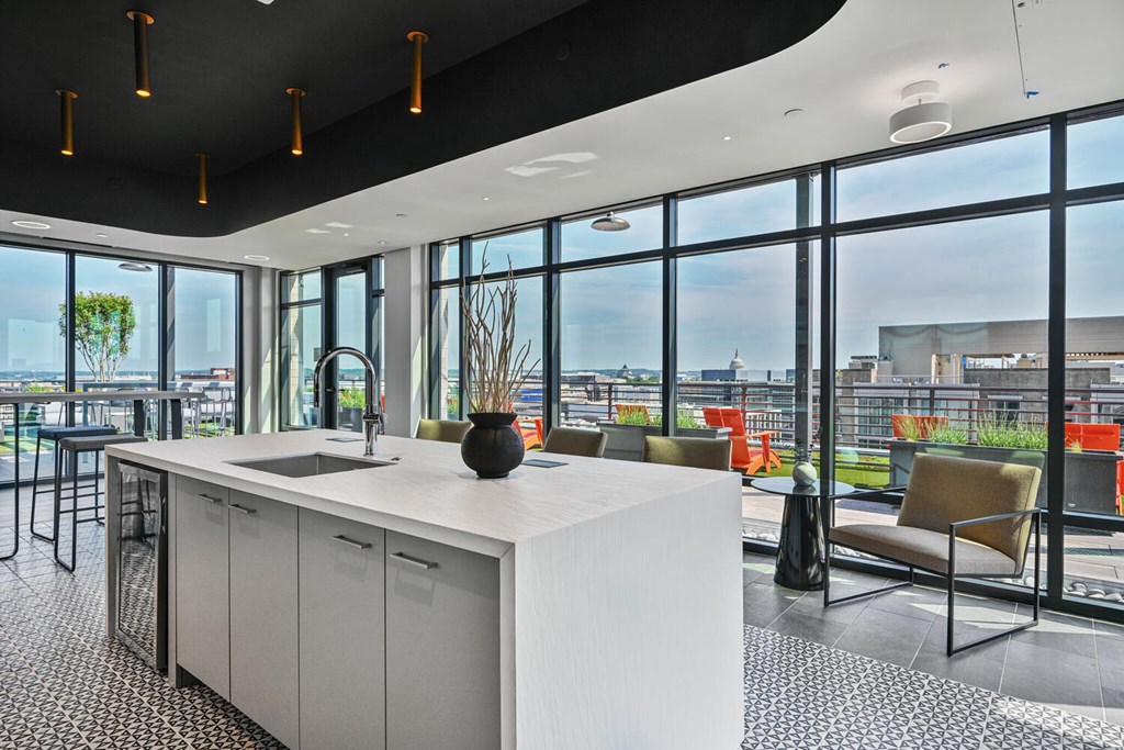 A modern kitchen with a large island and a view of the city.