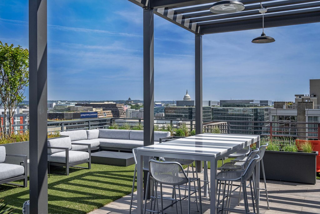 A patio with a table and chairs overlooking a city skyline.