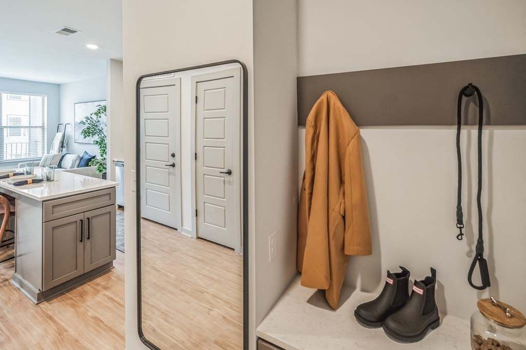 a bathroom with a sink and a mirror and a coat hanging on the wall at Preston Ridge, Cary