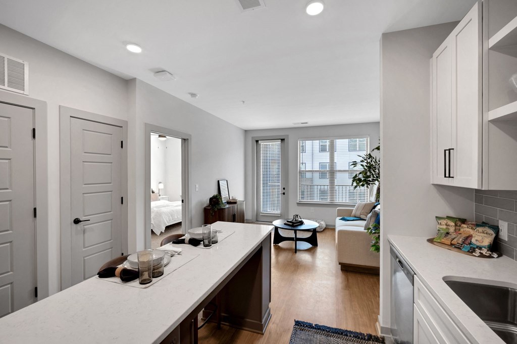 a kitchen with an island and a living room with a couch at Preston Ridge, Cary