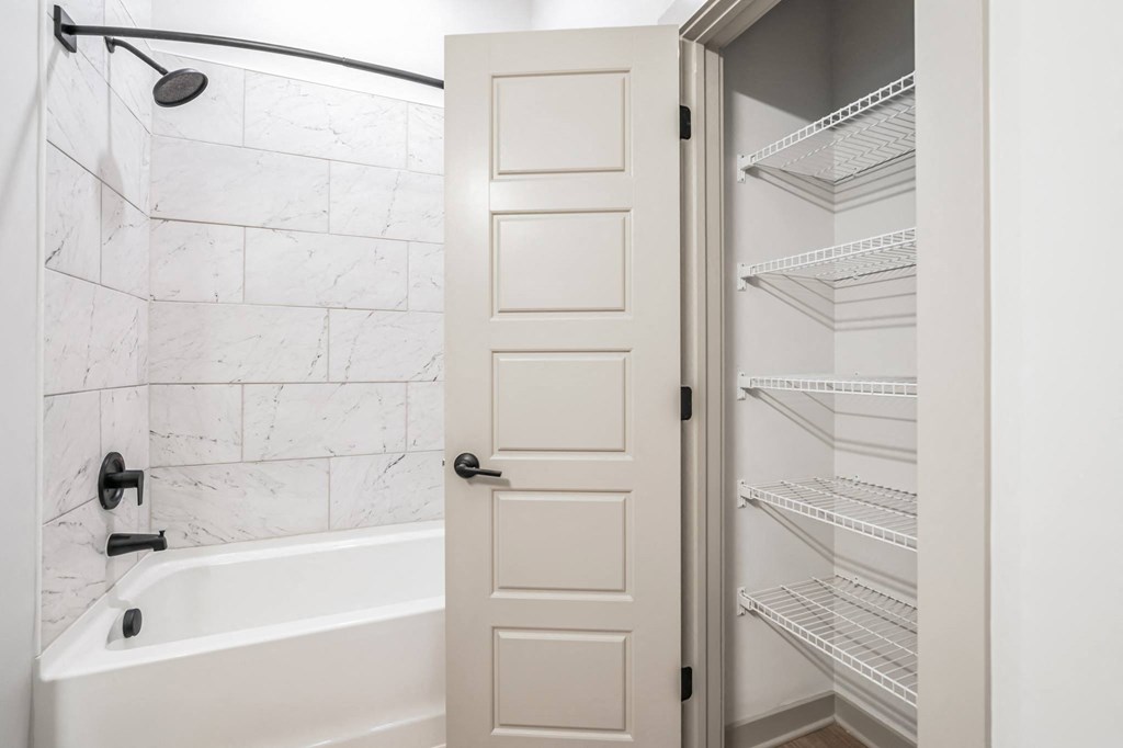a white bathroom with a tub and a closet at Preston Ridge, Cary, 27513