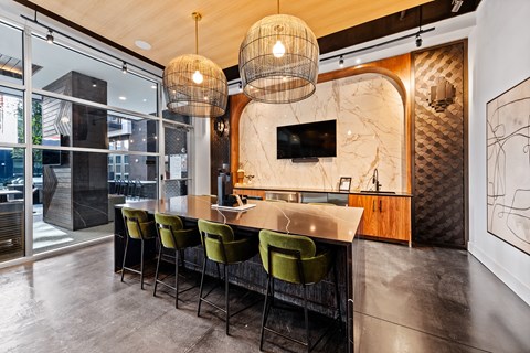 a kitchen with a marble counter top and green chairs