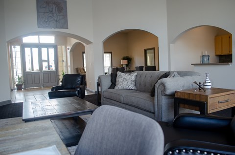 A living room with a grey couch and a black chair.