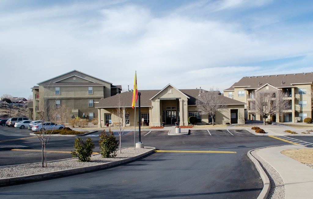 A large building with a flag in front of it. A large building with a flag in front of it at Arrowhead Ridge Apartments, Rio Rancho, NM