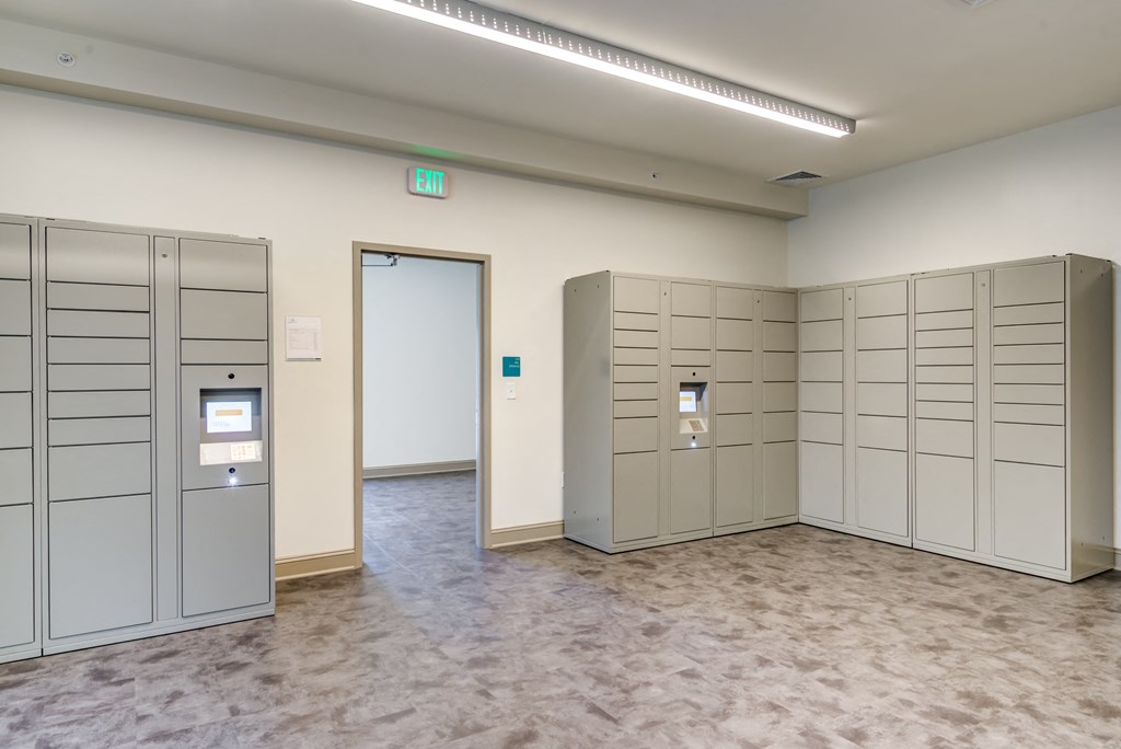 a group of lockers in a room with a door to a hallway
