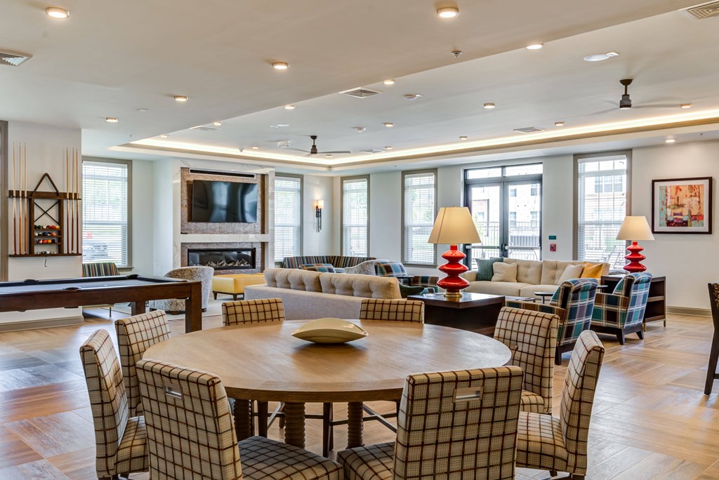 a large living room with a table and chairs and a fireplace