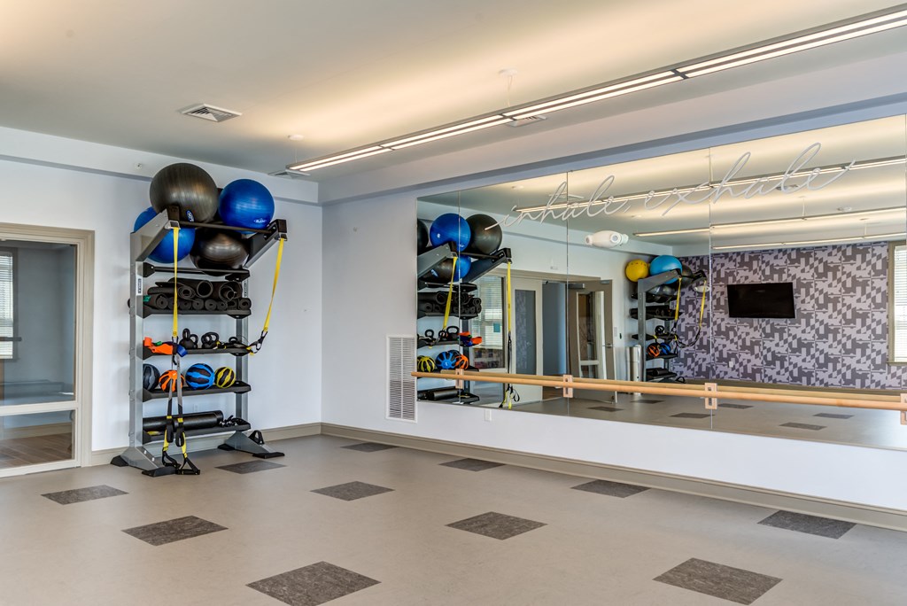 a workout room with weights and a mirror on the wall