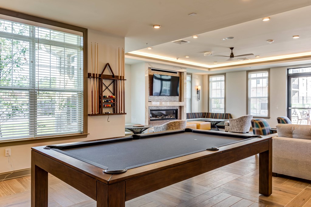 a pool table in the center of a living room with a fireplace