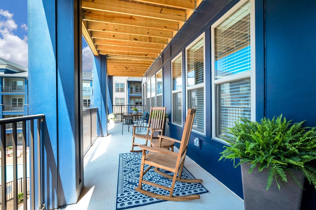 a porch with blue walls and a wooden rocking chair at Preston Ridge, Cary, 27513