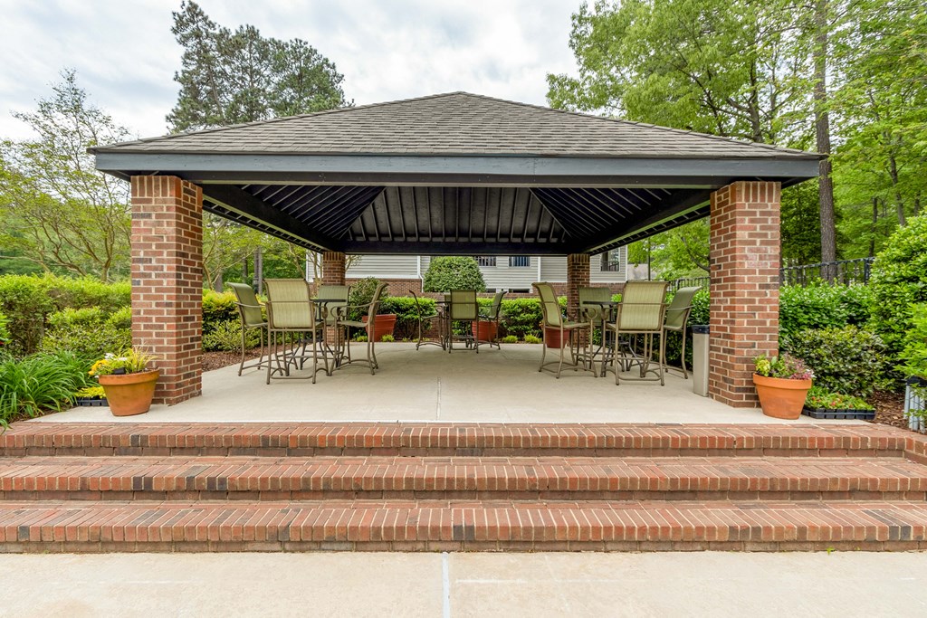 a gazebo with chairs and a table on a patio