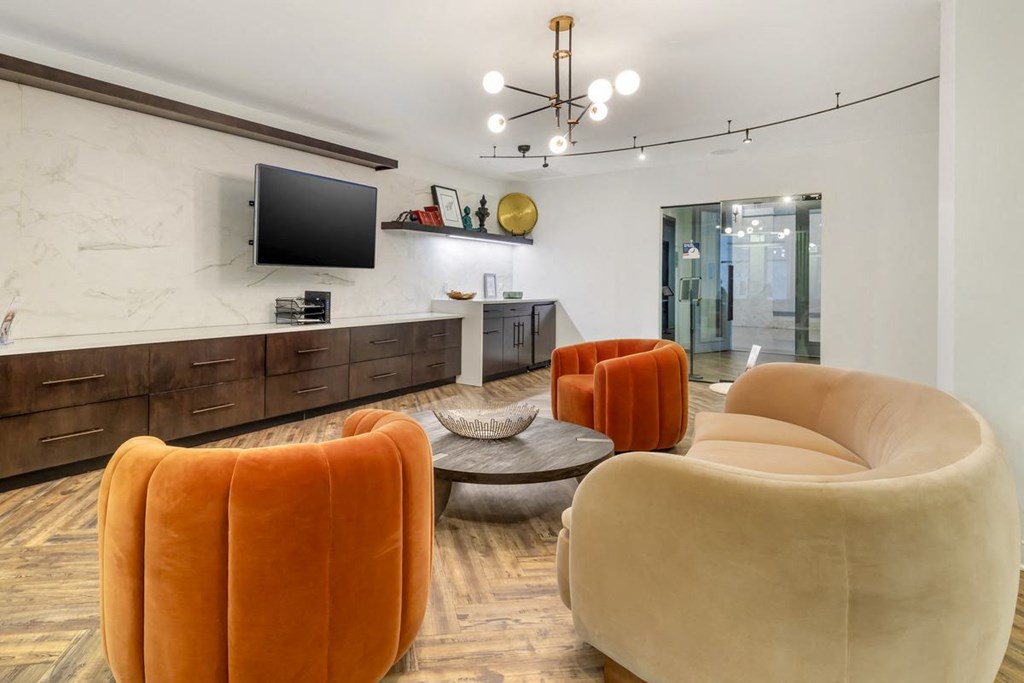 a living room with orange chairs and a televisionat the Equitable Building, Baltimore, MD, 21202