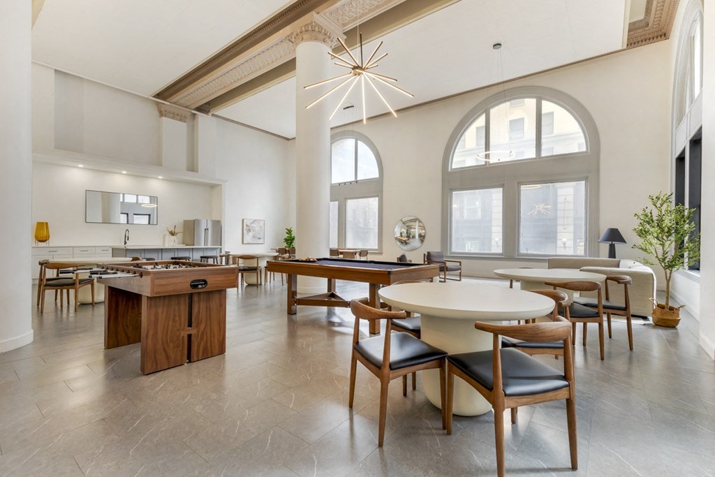 a dining room with tables and chairs and a large window at The Harriet Apartments, Maryland