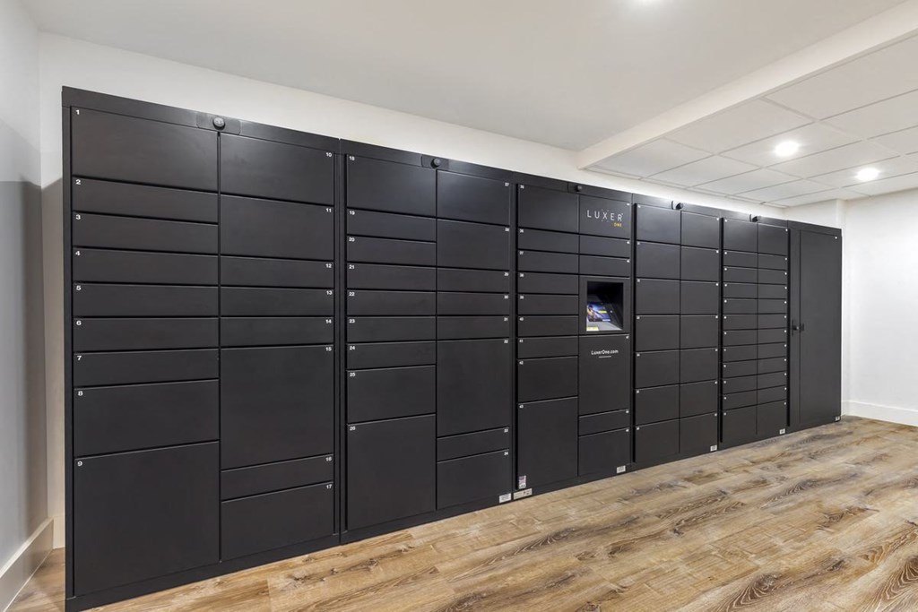 a large black lockers in a room with wooden floors at The Harriet Apartments, Maryland, 21202