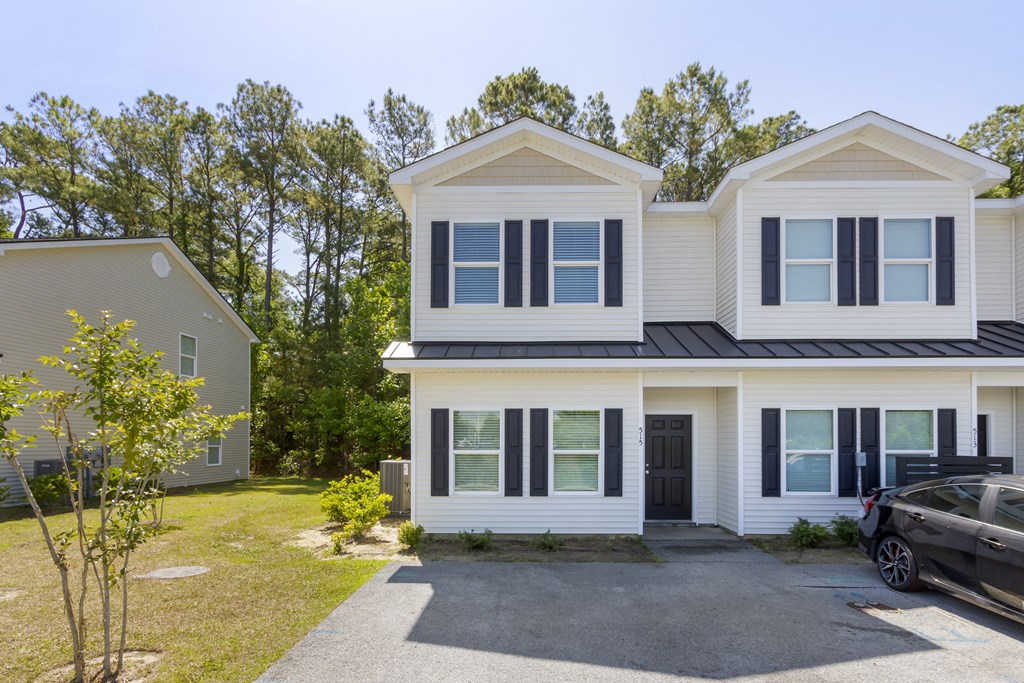 the front of the house with a car in the driveway and trees in the background  at Waverly Place, South Carolina