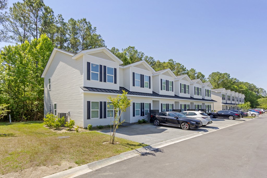 a row of houses with cars parked in front of them  at Waverly Place, North Charleston