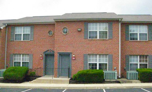 a red brick apartment building with blue doors and windows