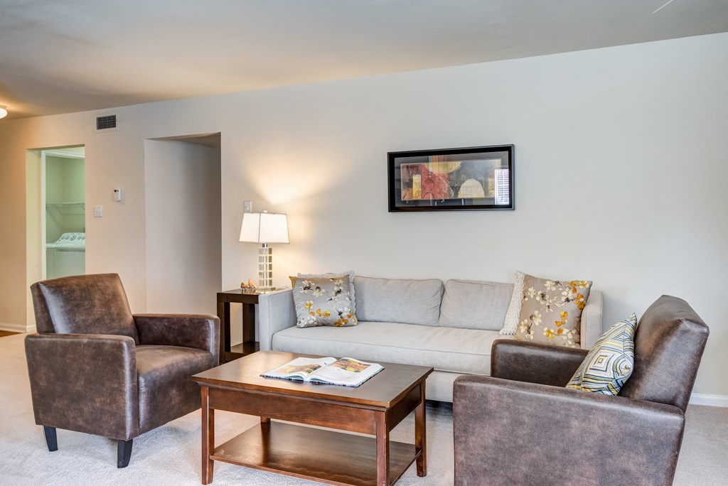 a living room with a couch and chairs and a coffee table