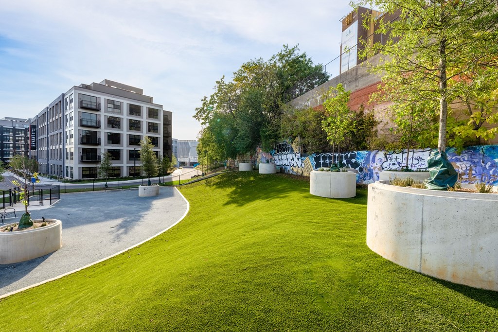 a park with green grass and a building in the background at The Chase at Bryant Street, Washington, DC 20002