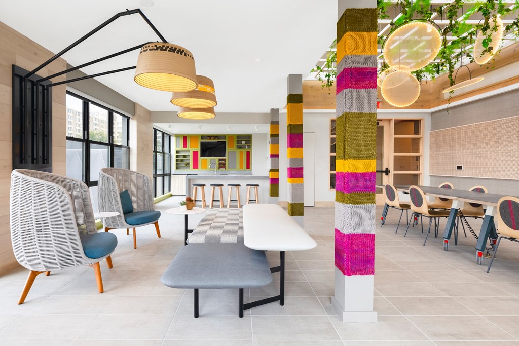 a rendering of a lobby with tables and chairs and a colorful column at The Chase at Bryant Street, District of Columbia