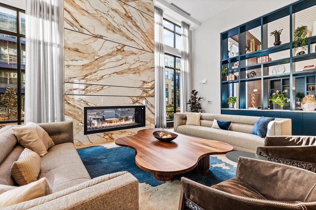 Clubhouse living room with a brown sofa and a wooden coffee table at Preston Ridge Apartments in Cary, NC.