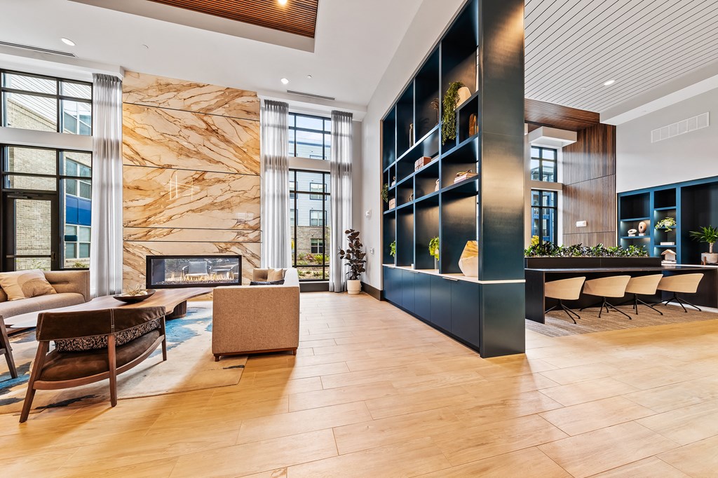 Clubhouse living room with a fireplace and a large marble wall at Preston Ridge Apartments in Cary, NC.