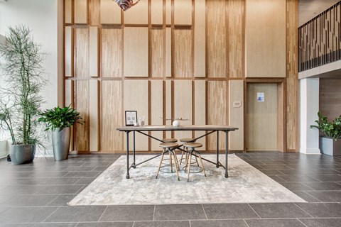 a dining room with a table and chairs in front of a wood wall at Coda at Bryant Street, Washington, DC