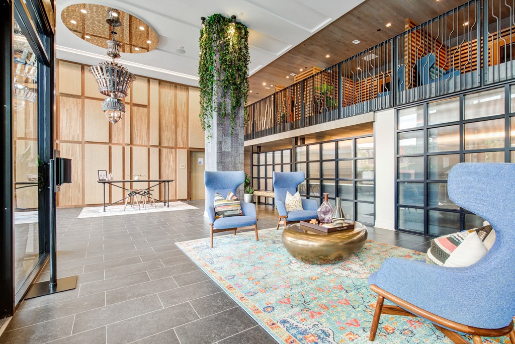 a lobby with blue chairs and a gold sculpture in the middle at Coda at Bryant Street, Washington, DC 20002