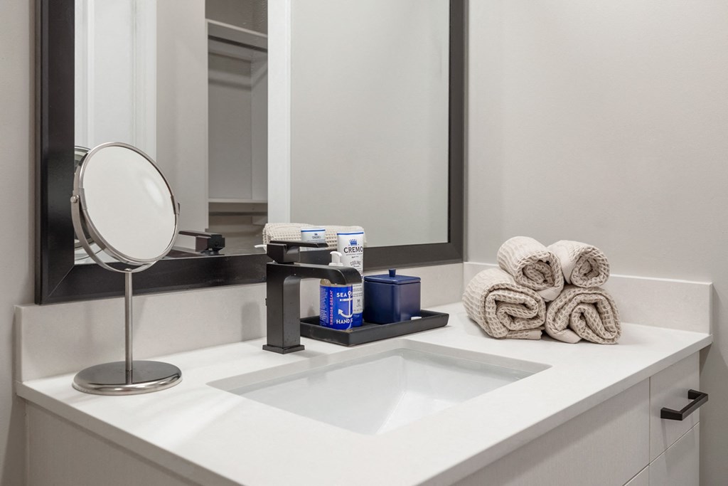 a bathroom with a sink and a mirror and towels at Coda at Bryant Street, Washington, DC