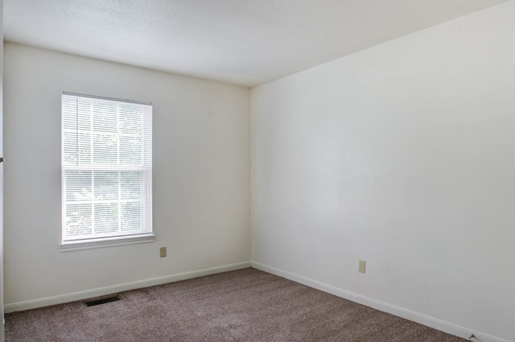 a bedroom with white walls and carpet
