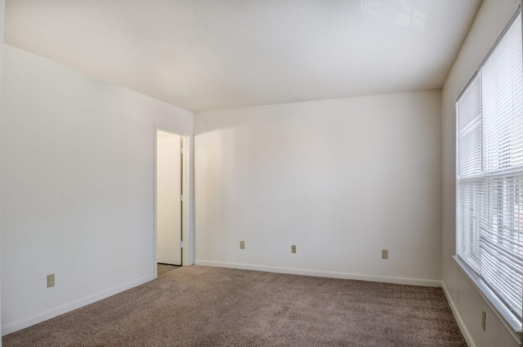 a bedroom with white walls and carpet